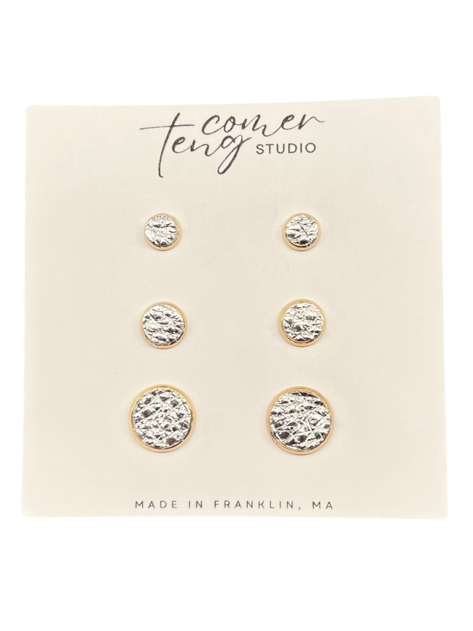 Set of silver stud earrings on a branded card from Covering Studio.