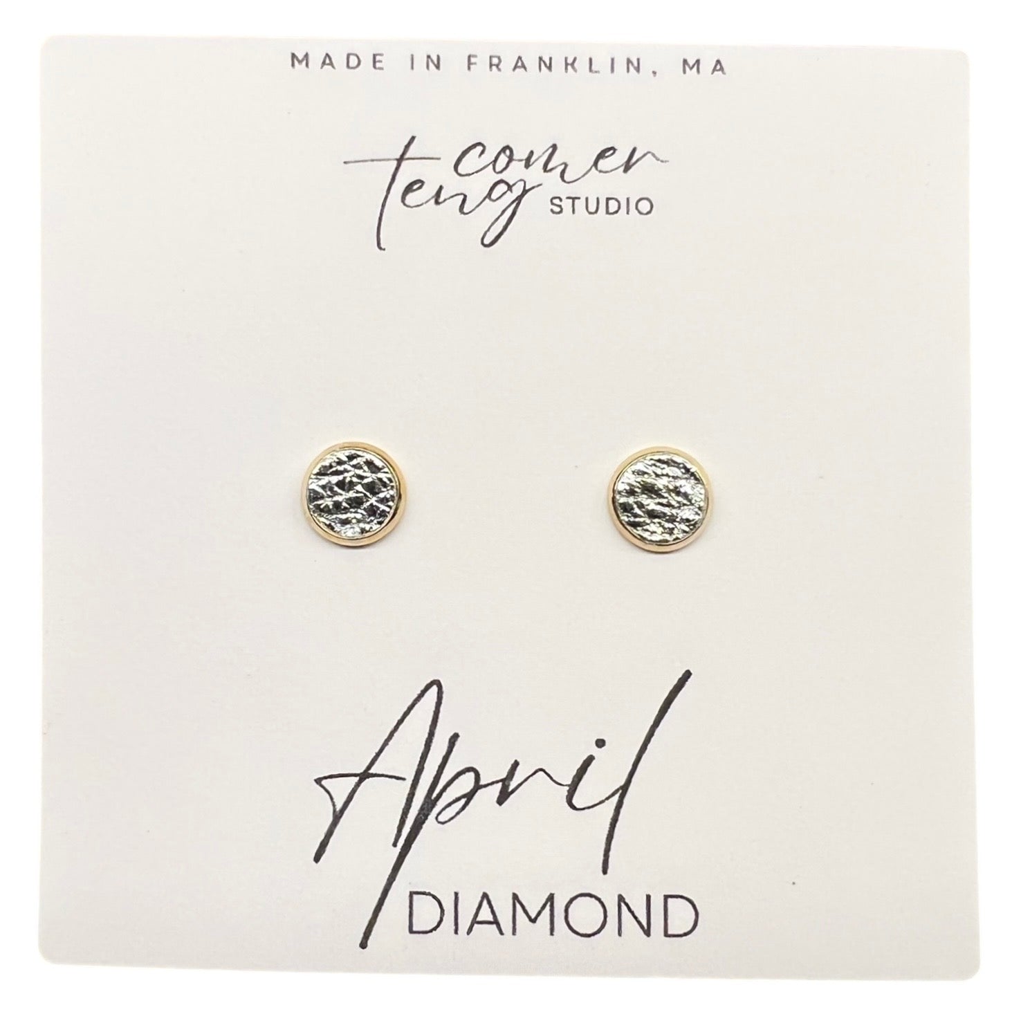 Pair of gold earrings on a card with branding and 'April Diamond' text.