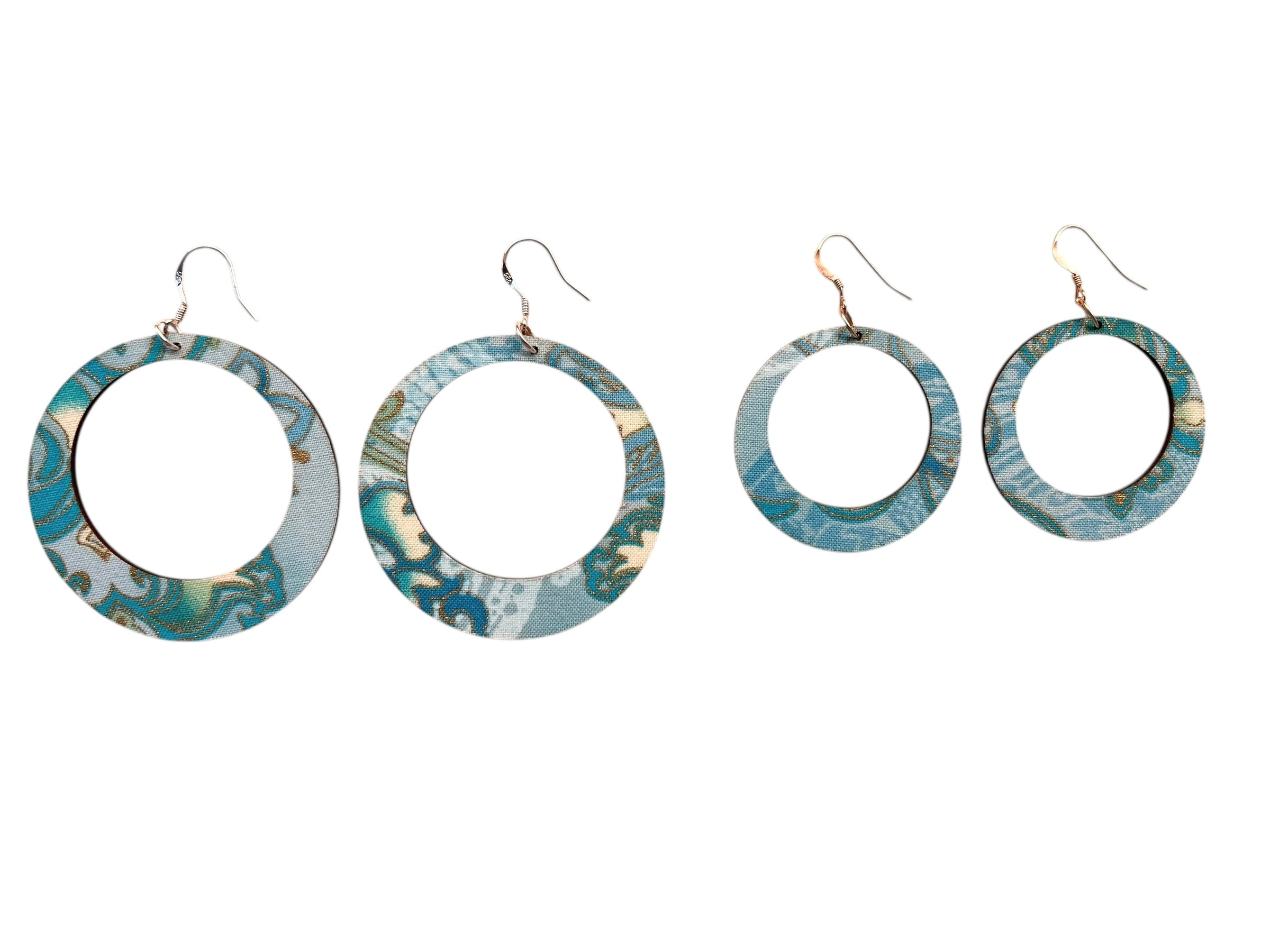 Set of four blue marbled hoop earrings on a white background