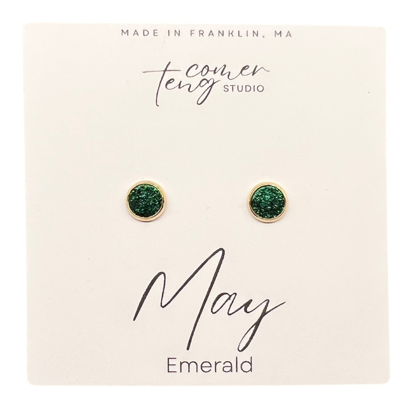 Green earrings on a card with branding and 'May Emerald' text.