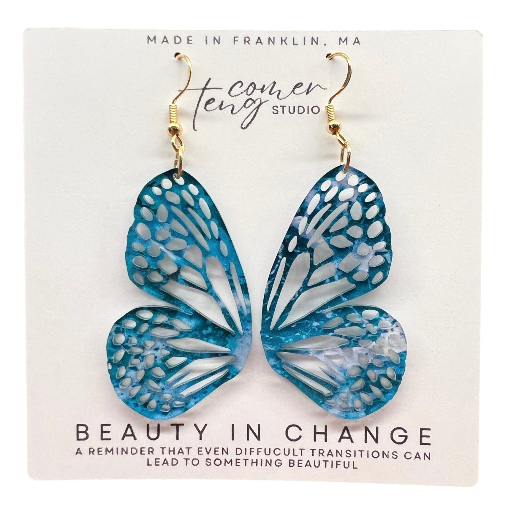 Blue butterfly earrings on a card with text and branding