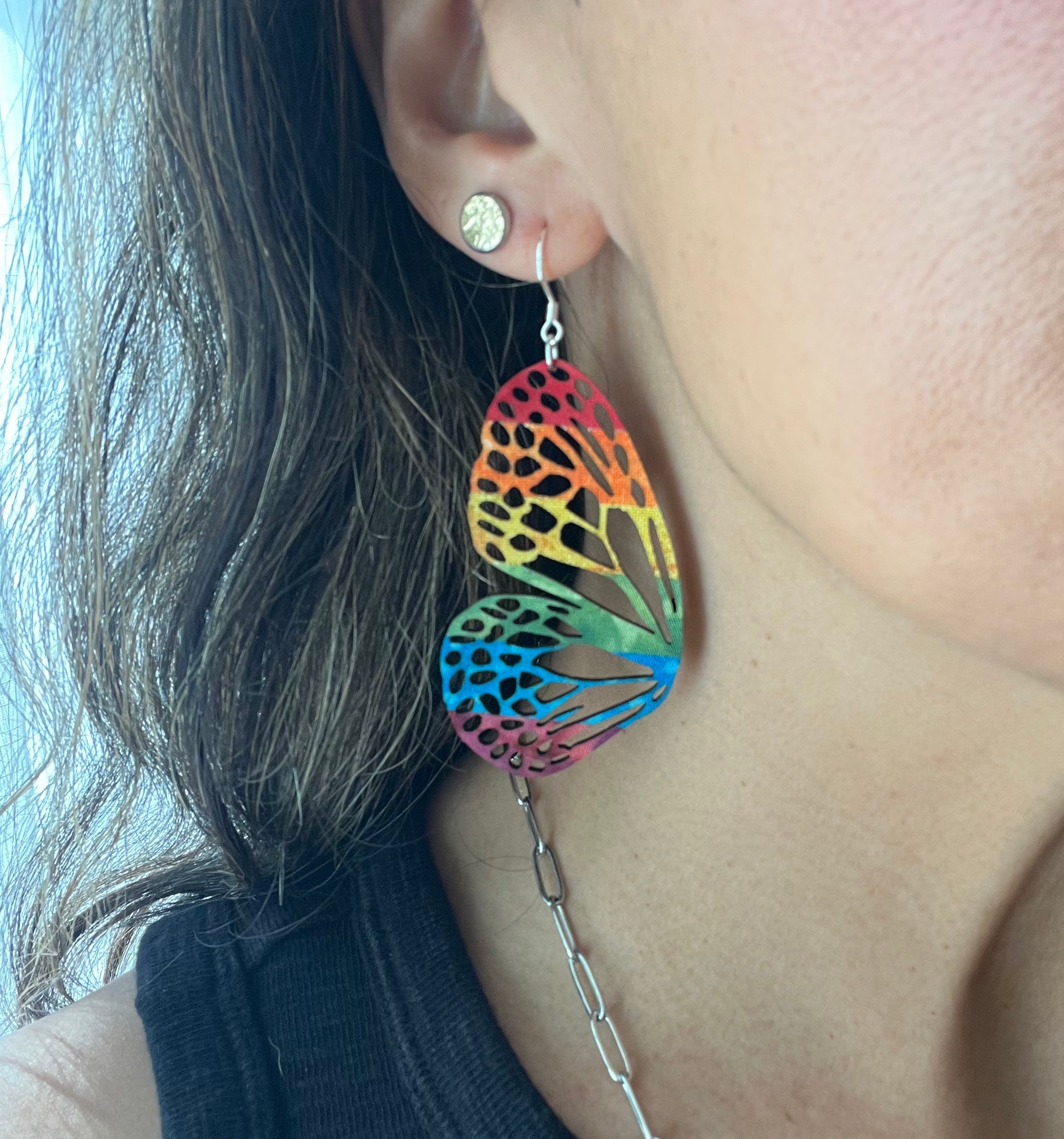 Close-up of a person wearing colorful earrings.