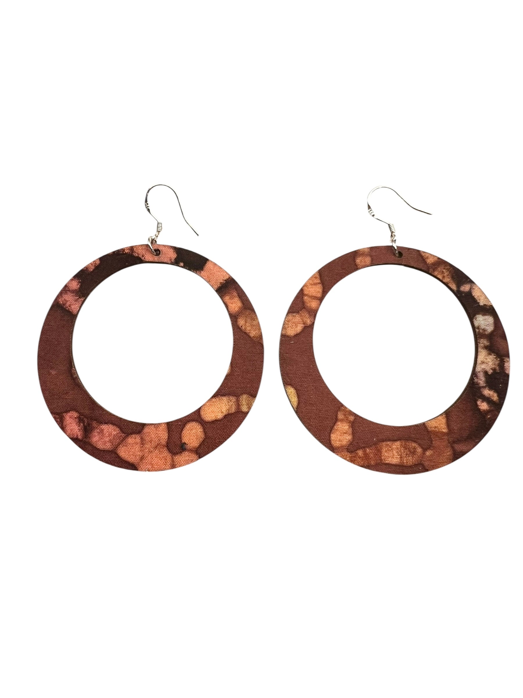 Pair of round earrings with a cork-like texture on a white background