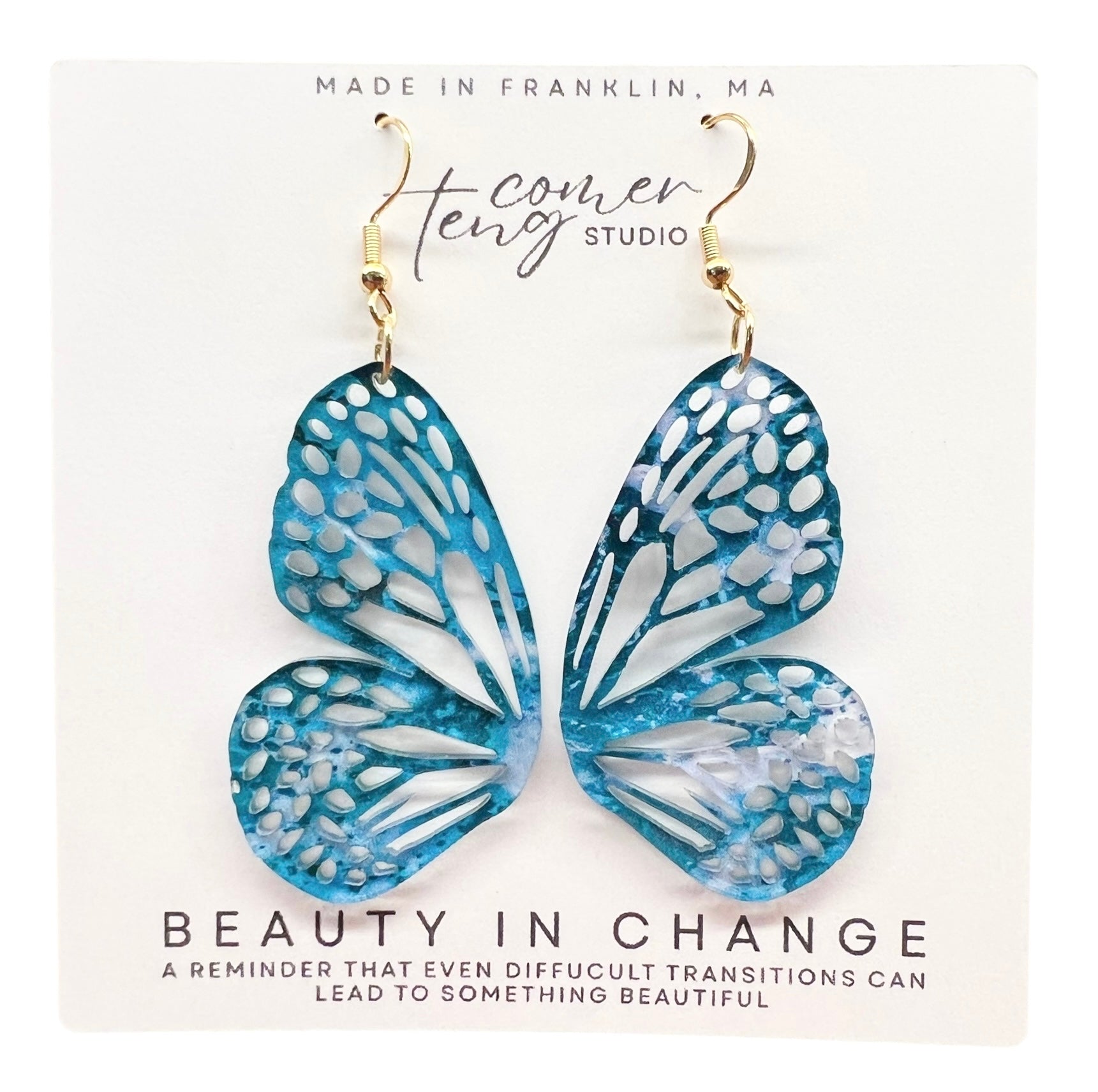 Butterfly-shaped earrings on a card with text and branding