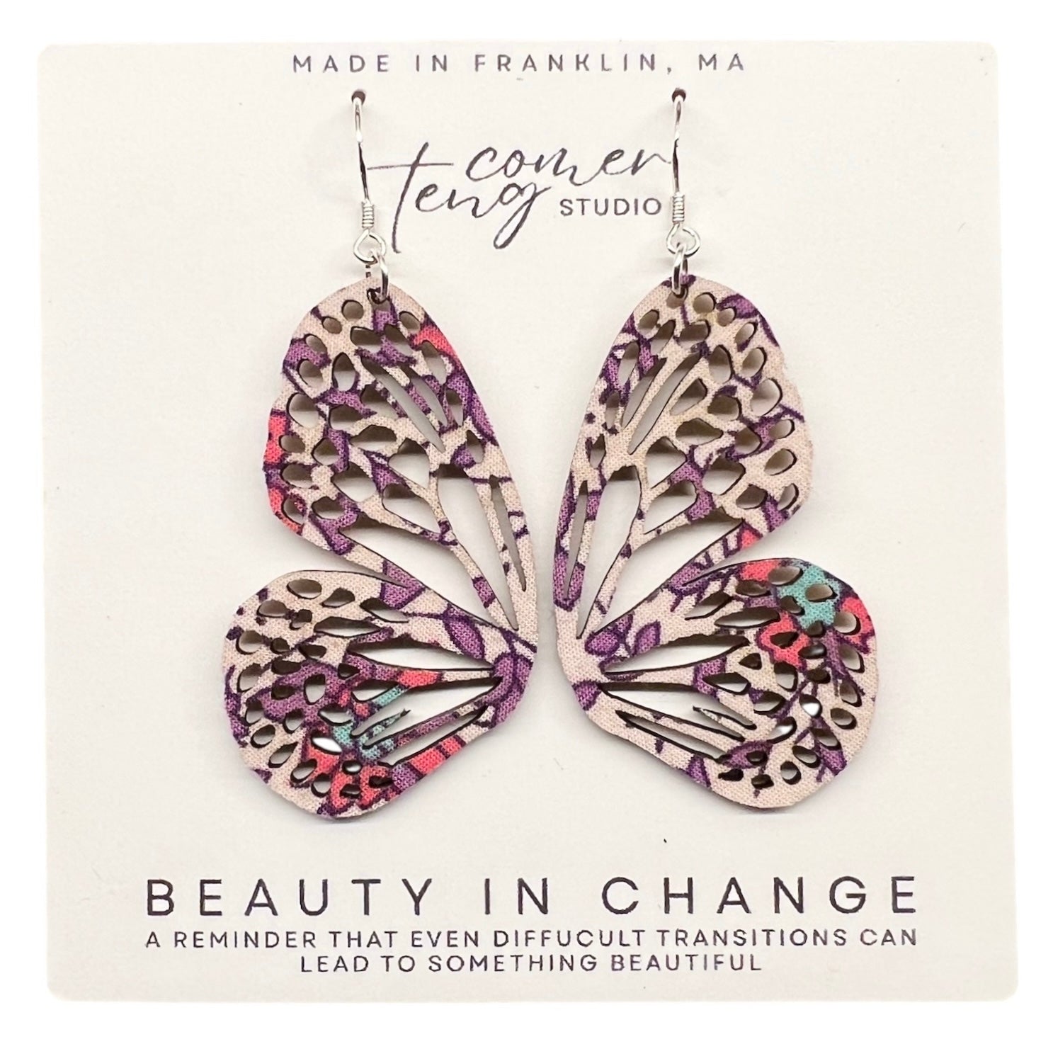 Pair of floral patterned earrings on a Beauty in Change Card.