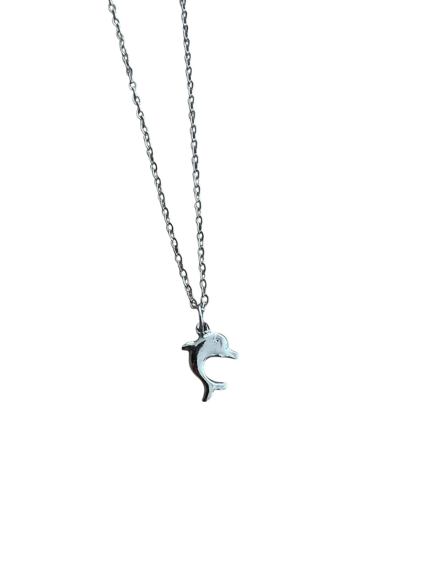 Dolphin pendant necklace on a thin chain against a white background