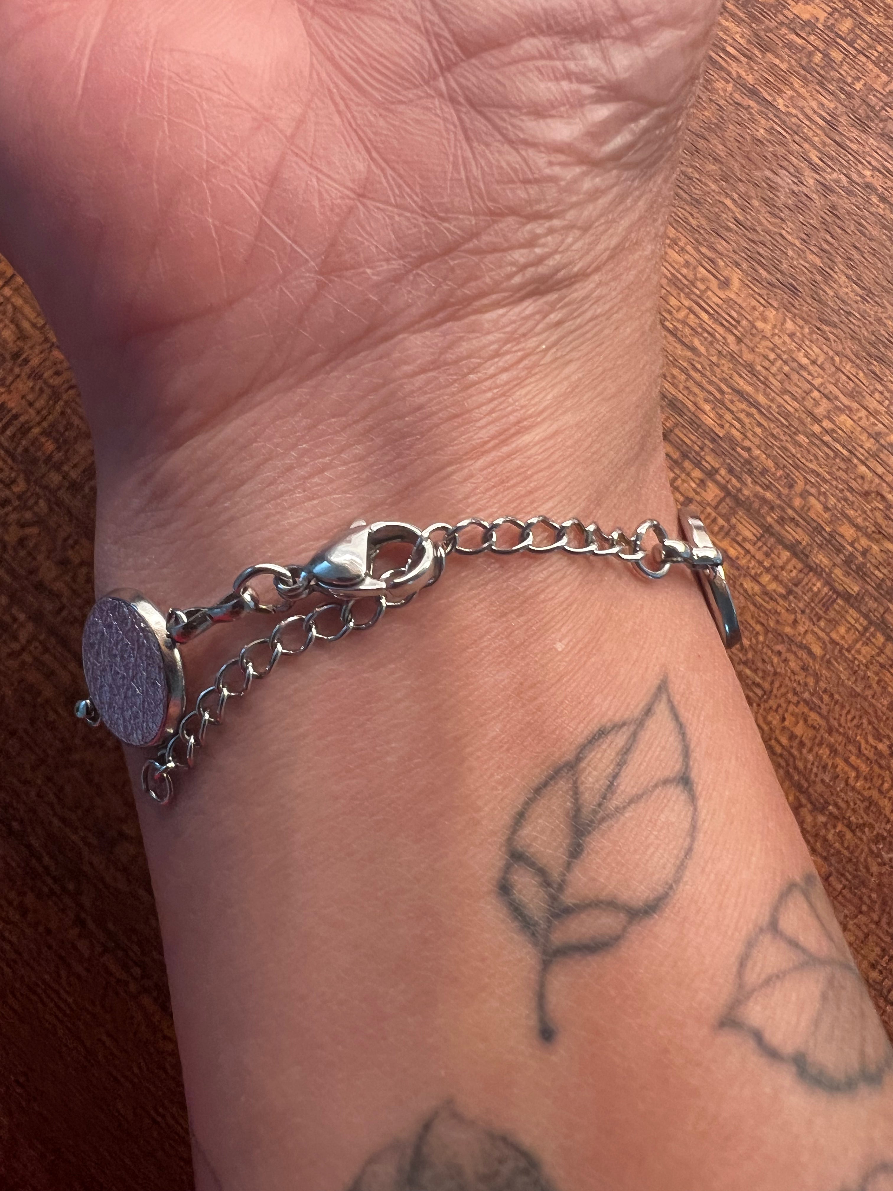 An image of a hand wearing the Everlink Bracelet with silver hardware