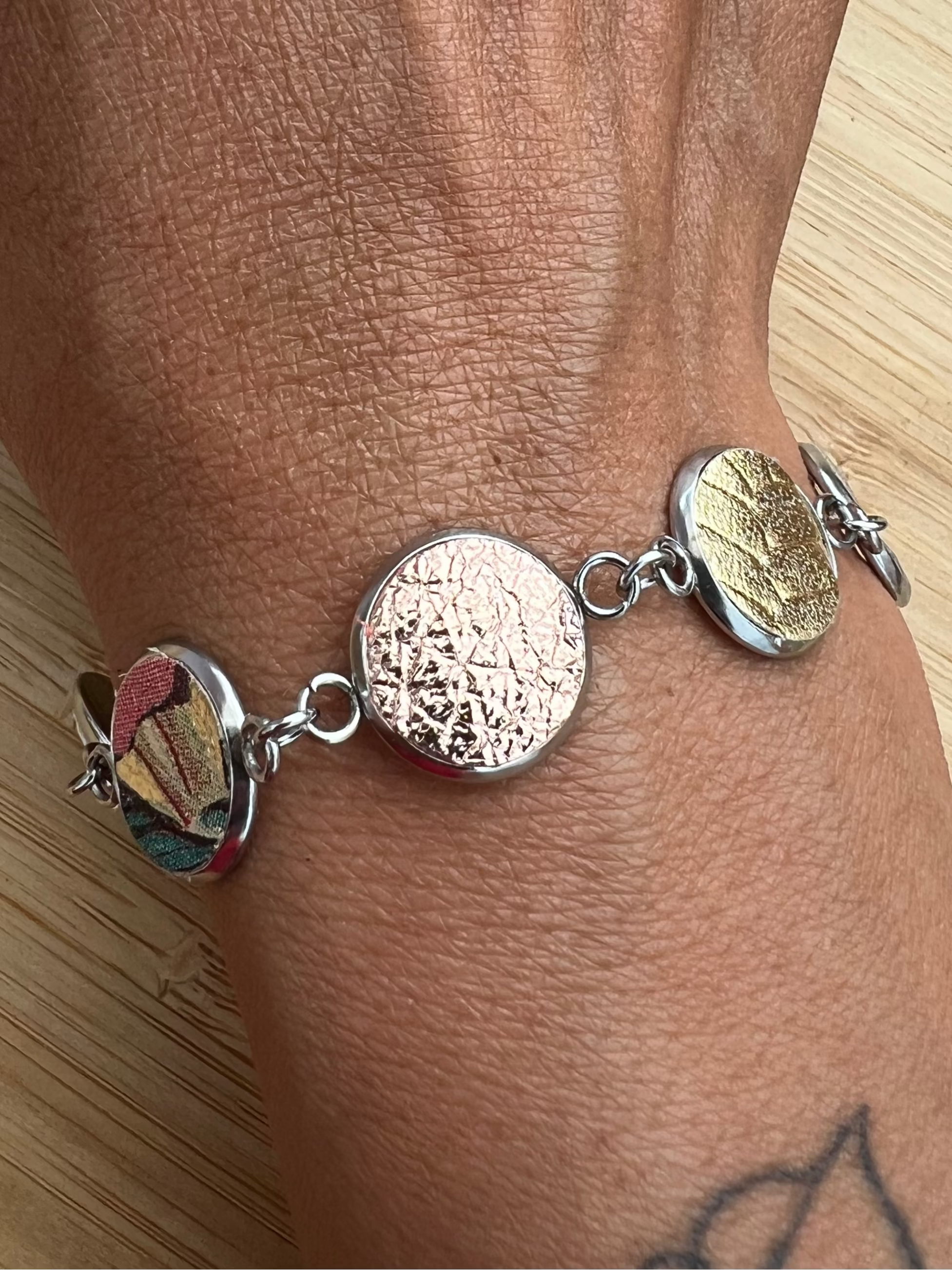 Everlink silver bracelet on a wrist against a wooden surface