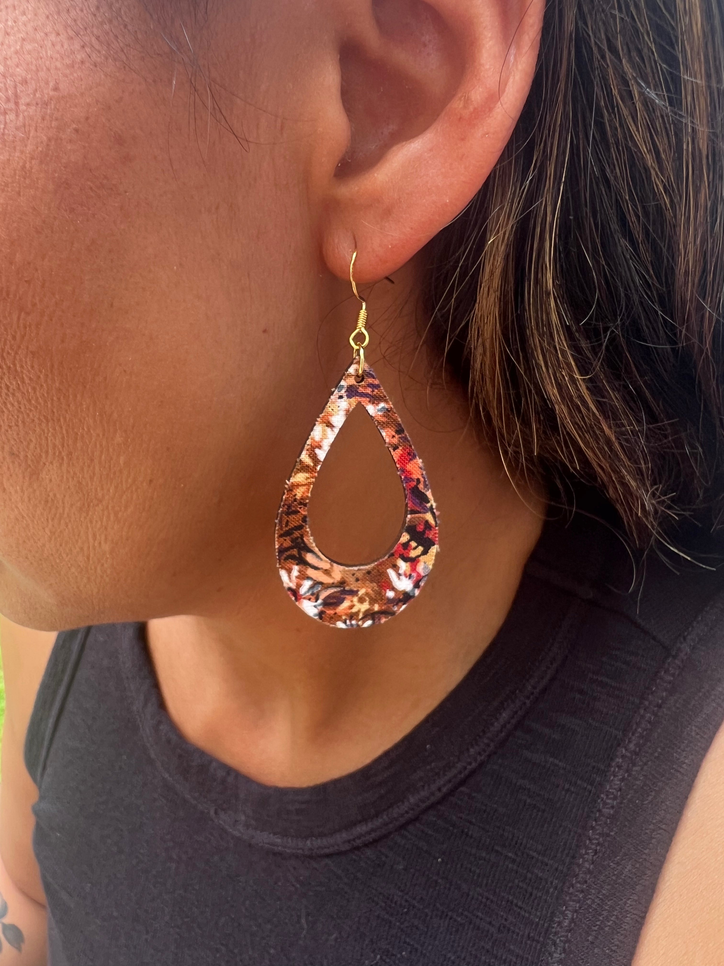 Close-up of a person wearing a patterned teardrop earring.