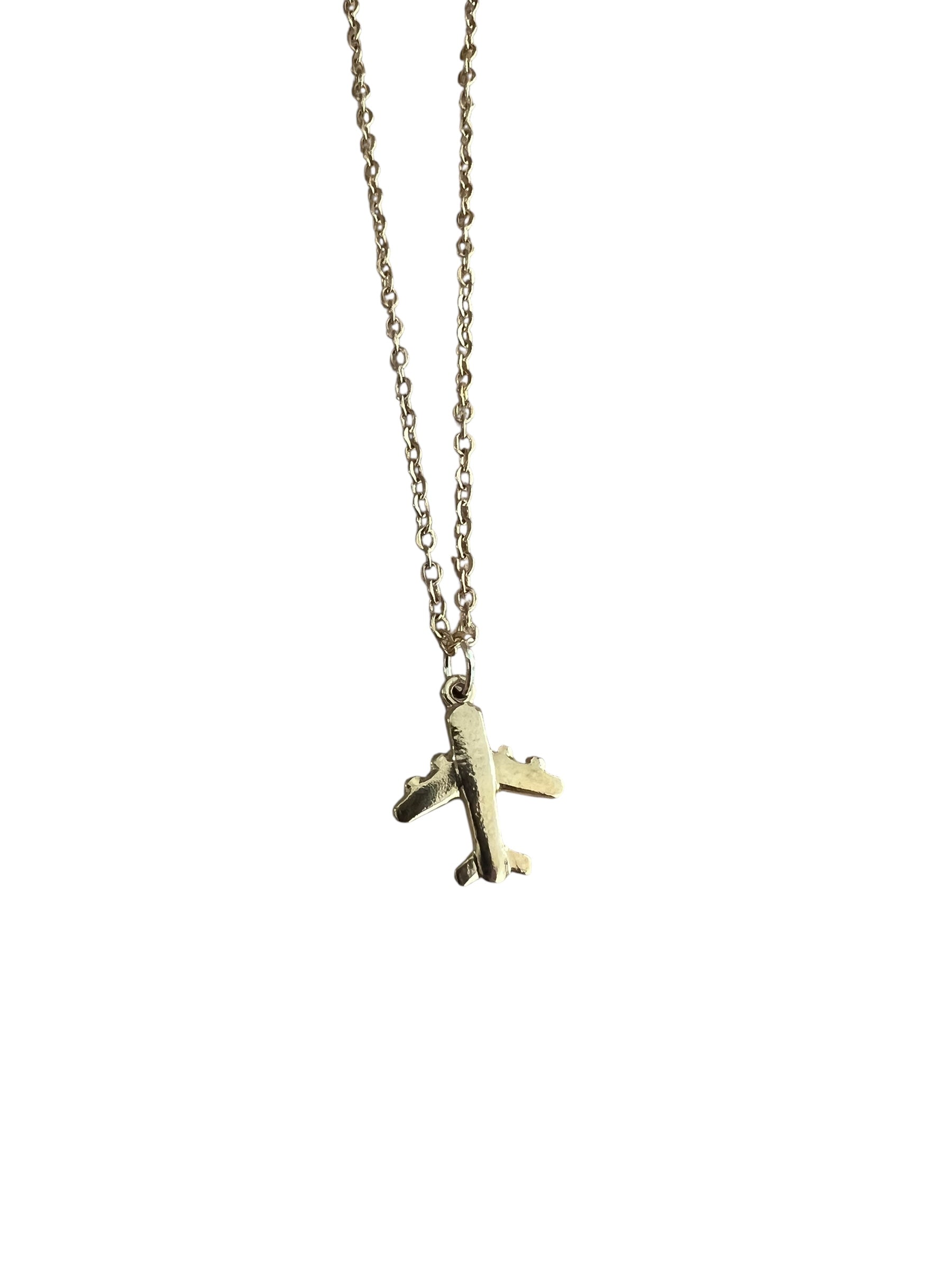 Gold airplane pendant on a chain against a white background