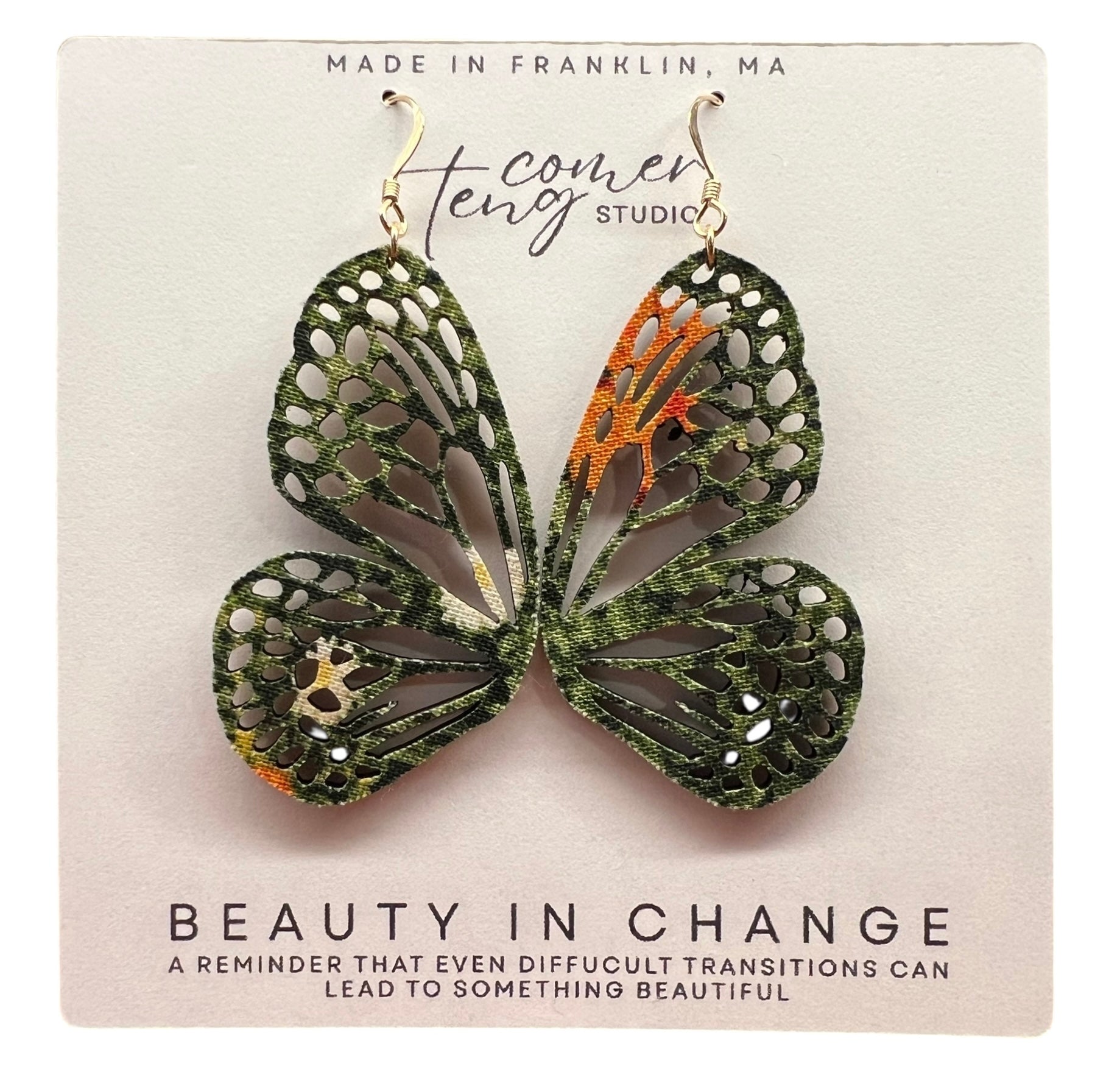 Butterfly-shaped earrings on a card with text and branding