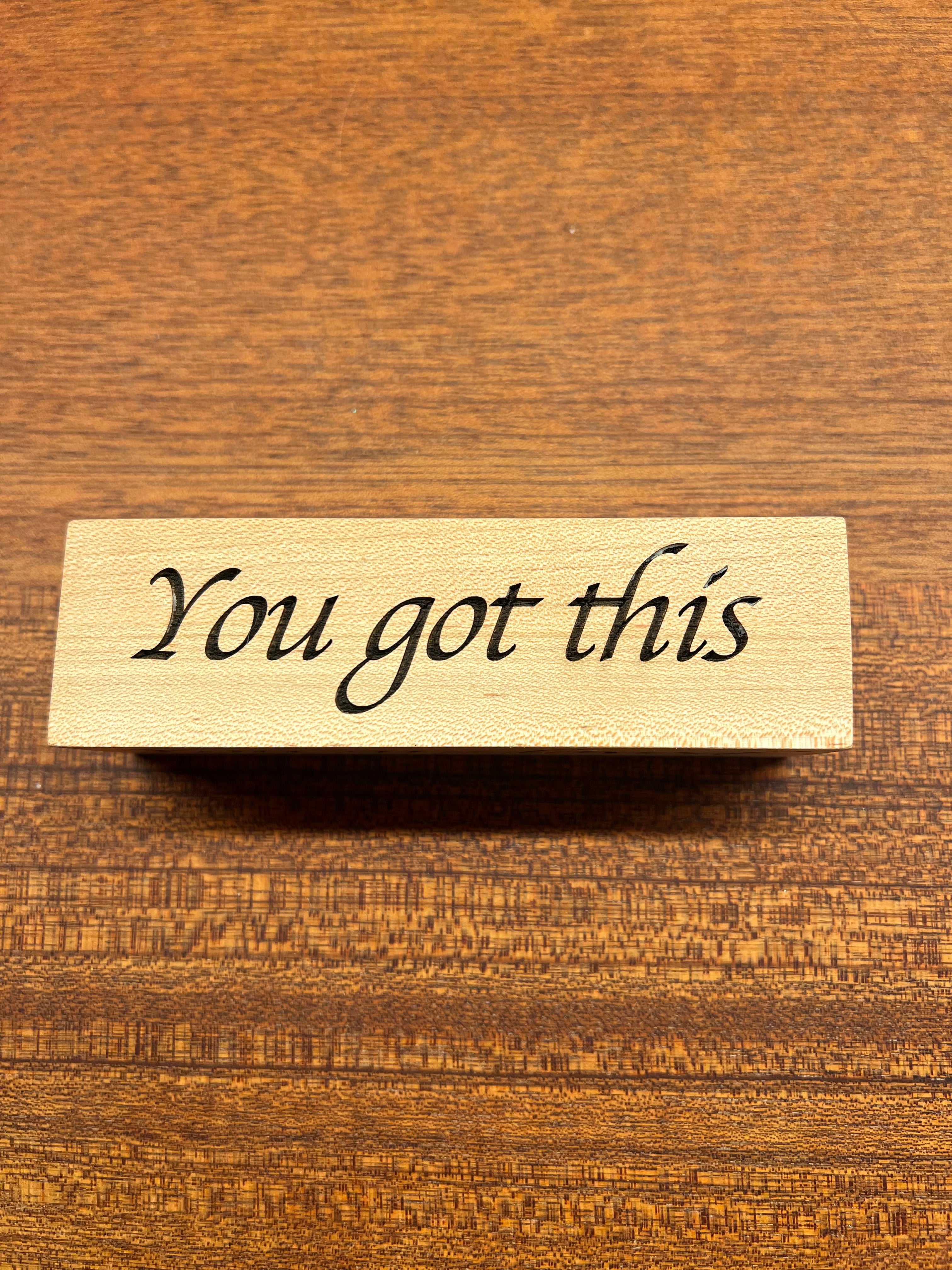 Wooden block with 'You got this' text on a wooden background