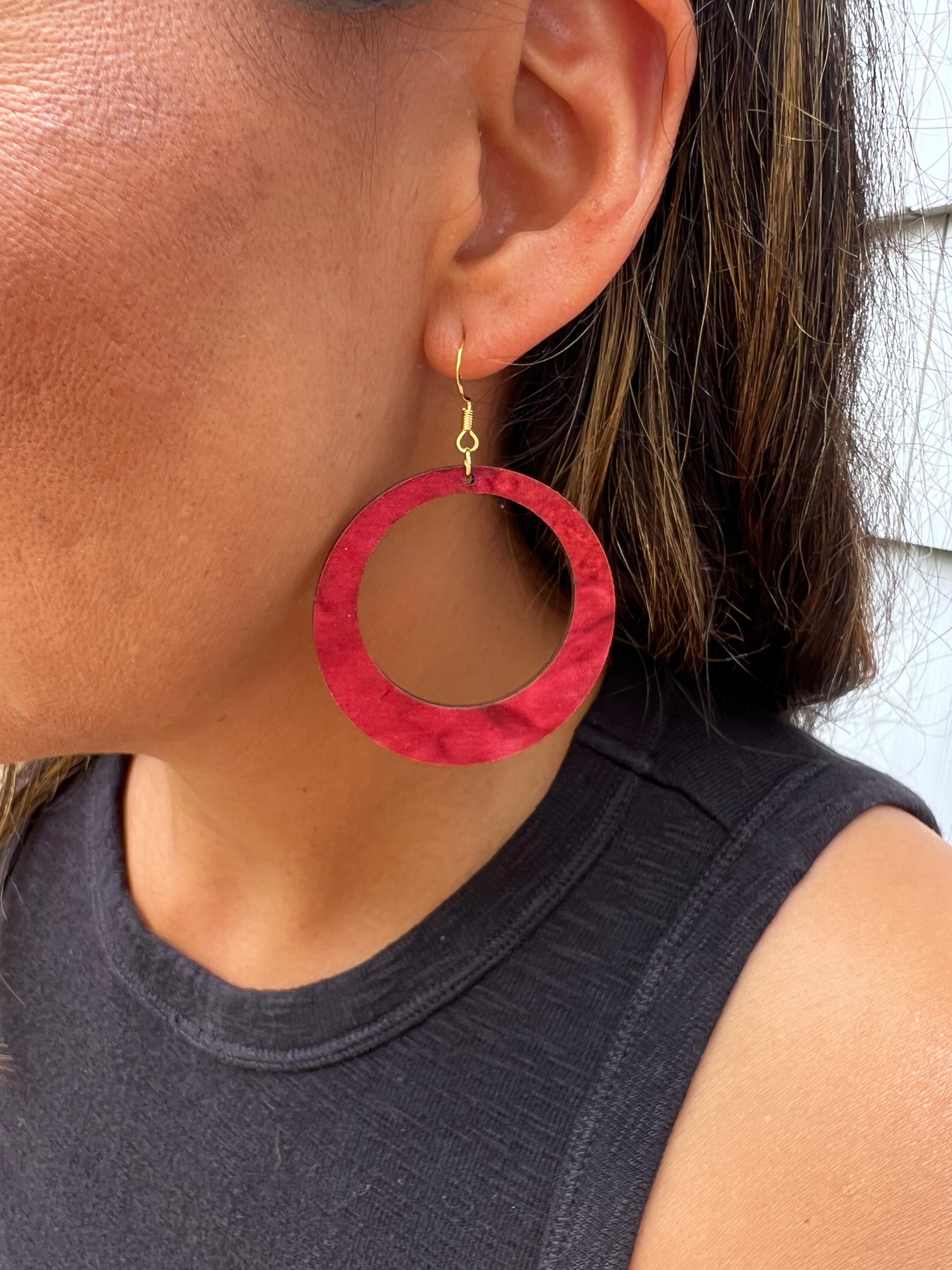 Red hoop earring worn by a person with a neutral background