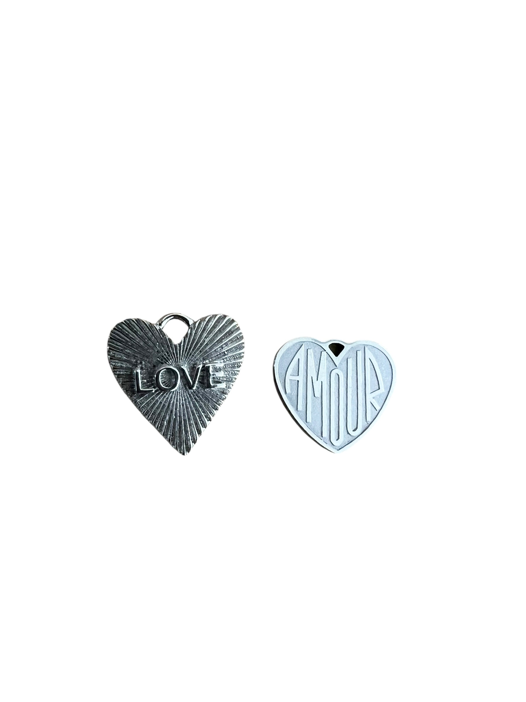 Two heart-shaped charms on a white background