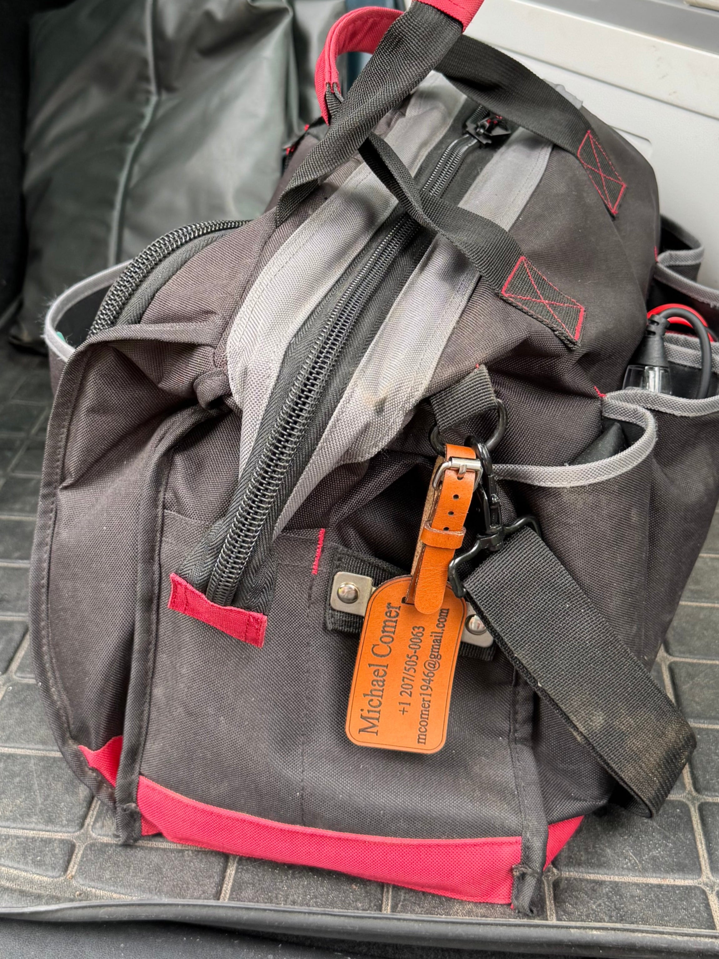 Gray tool bag with red accents inside a vehicle