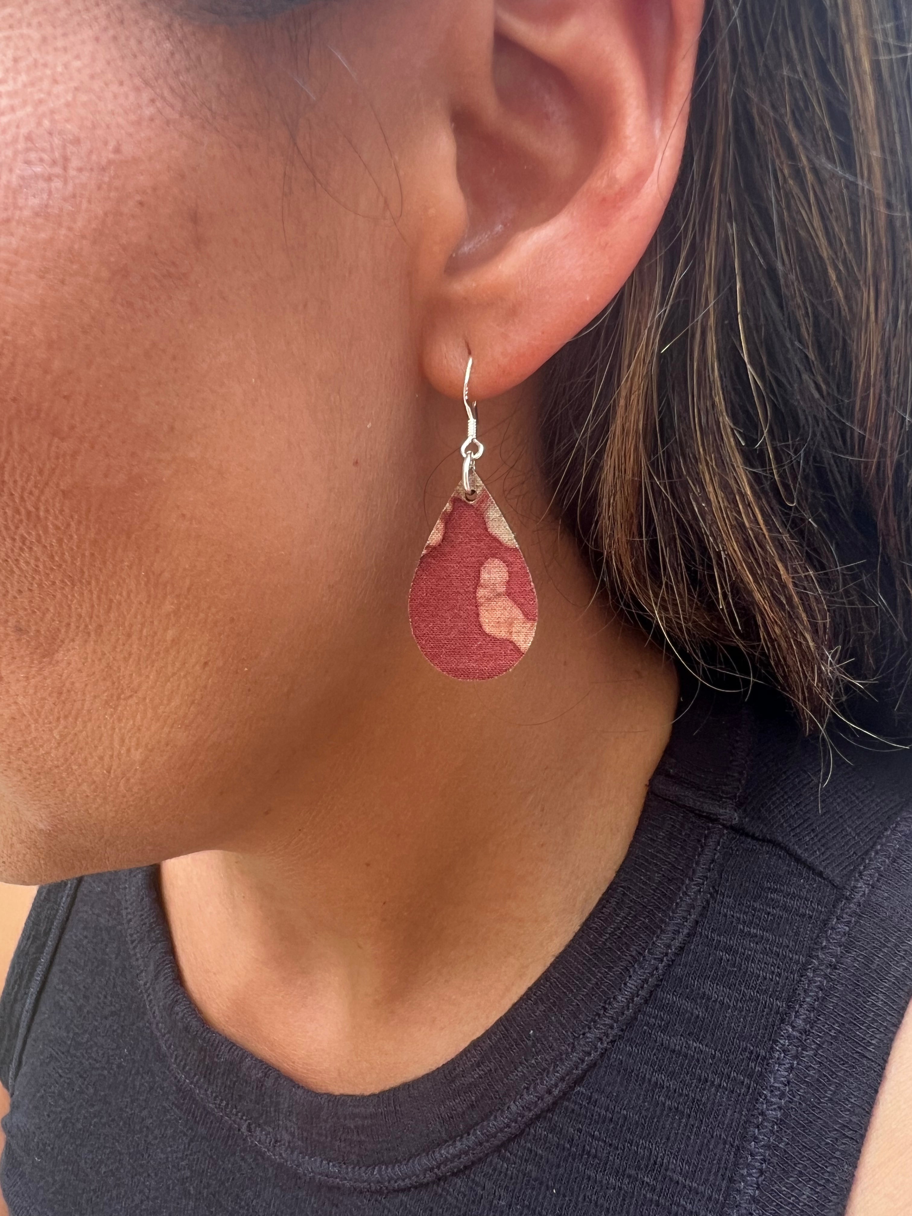 Close-up of a person wearing a brown teardrop earring.