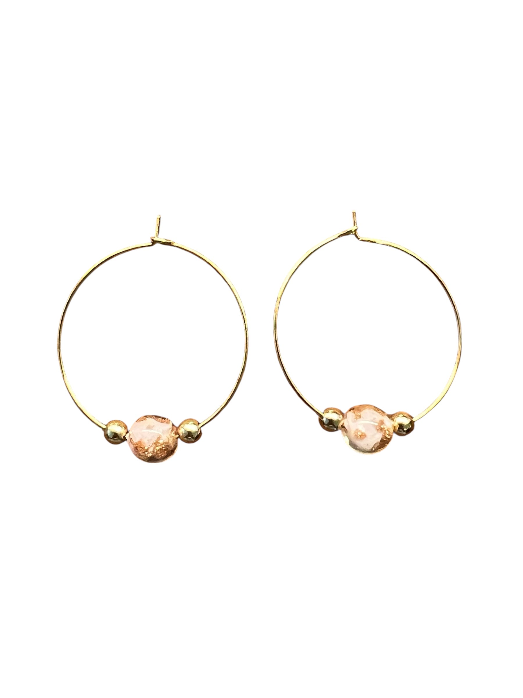 Gold hoop earrings with peach-colored beads on a white background