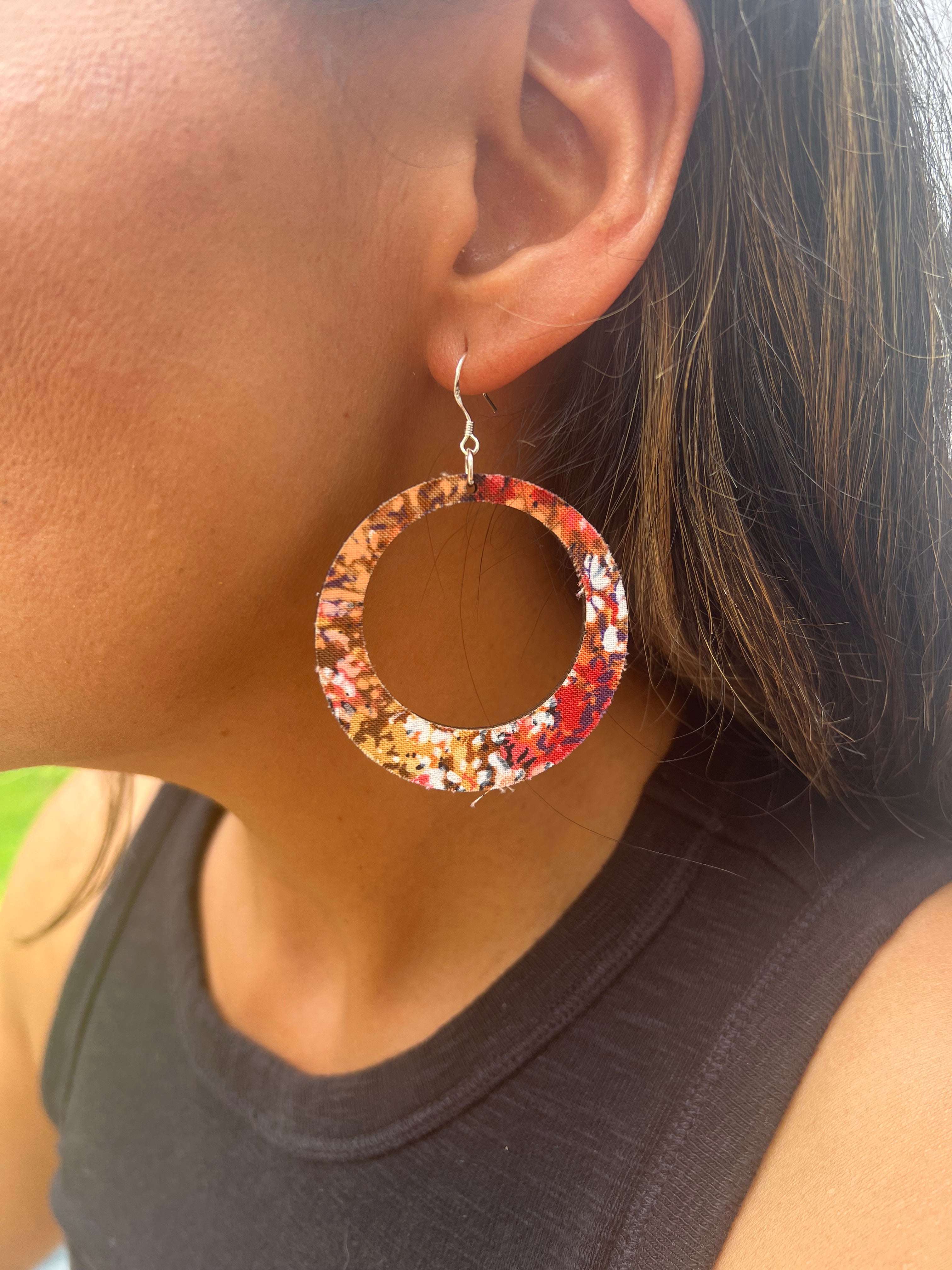 Close-up of a person wearing a colorful hoop earring.