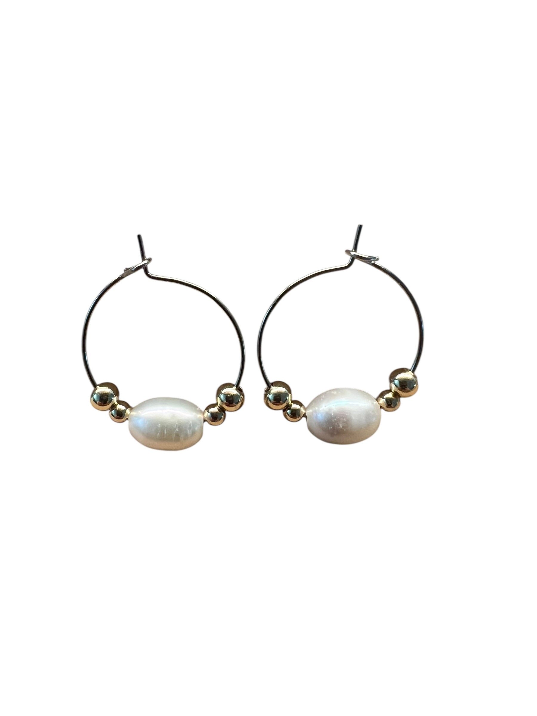 Pair of hoop earrings with pearls on a white background