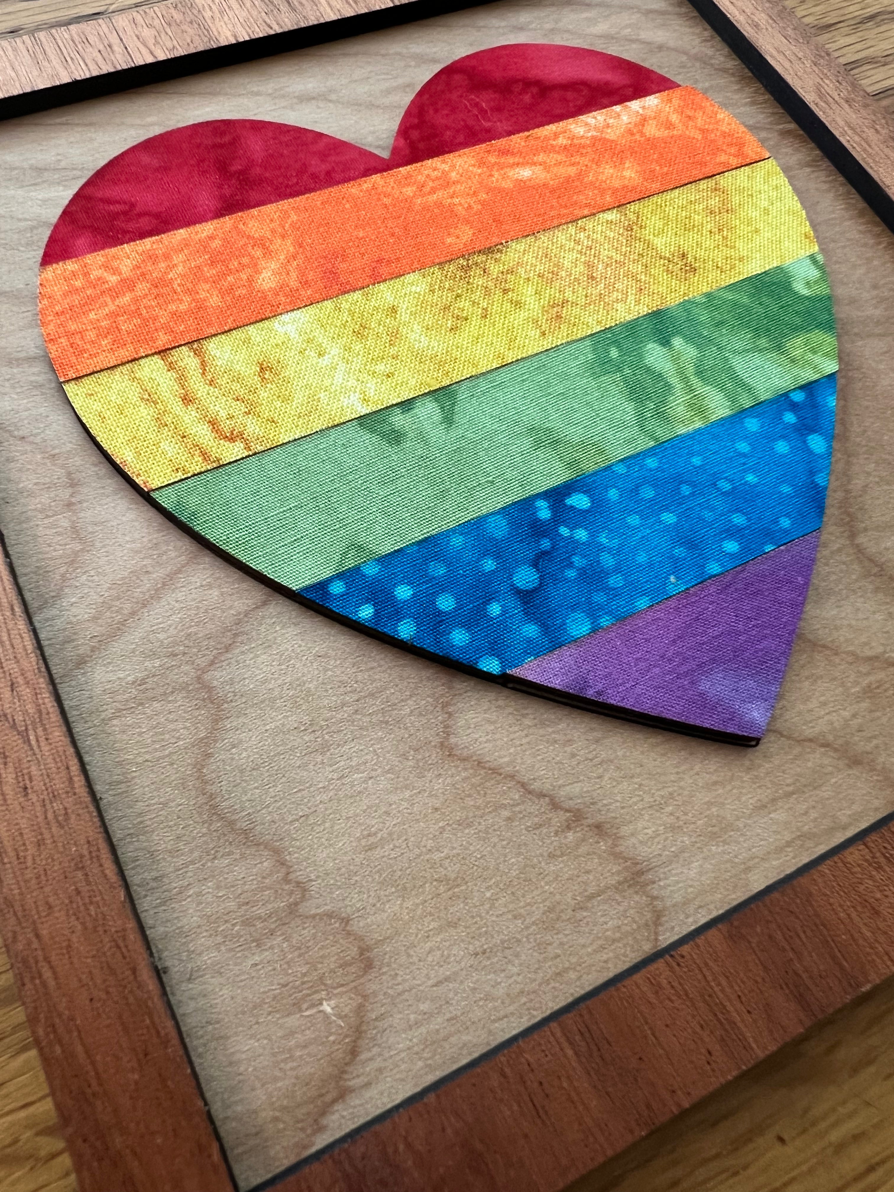 Heart-shaped patchwork with rainbow colors on a wooden surface