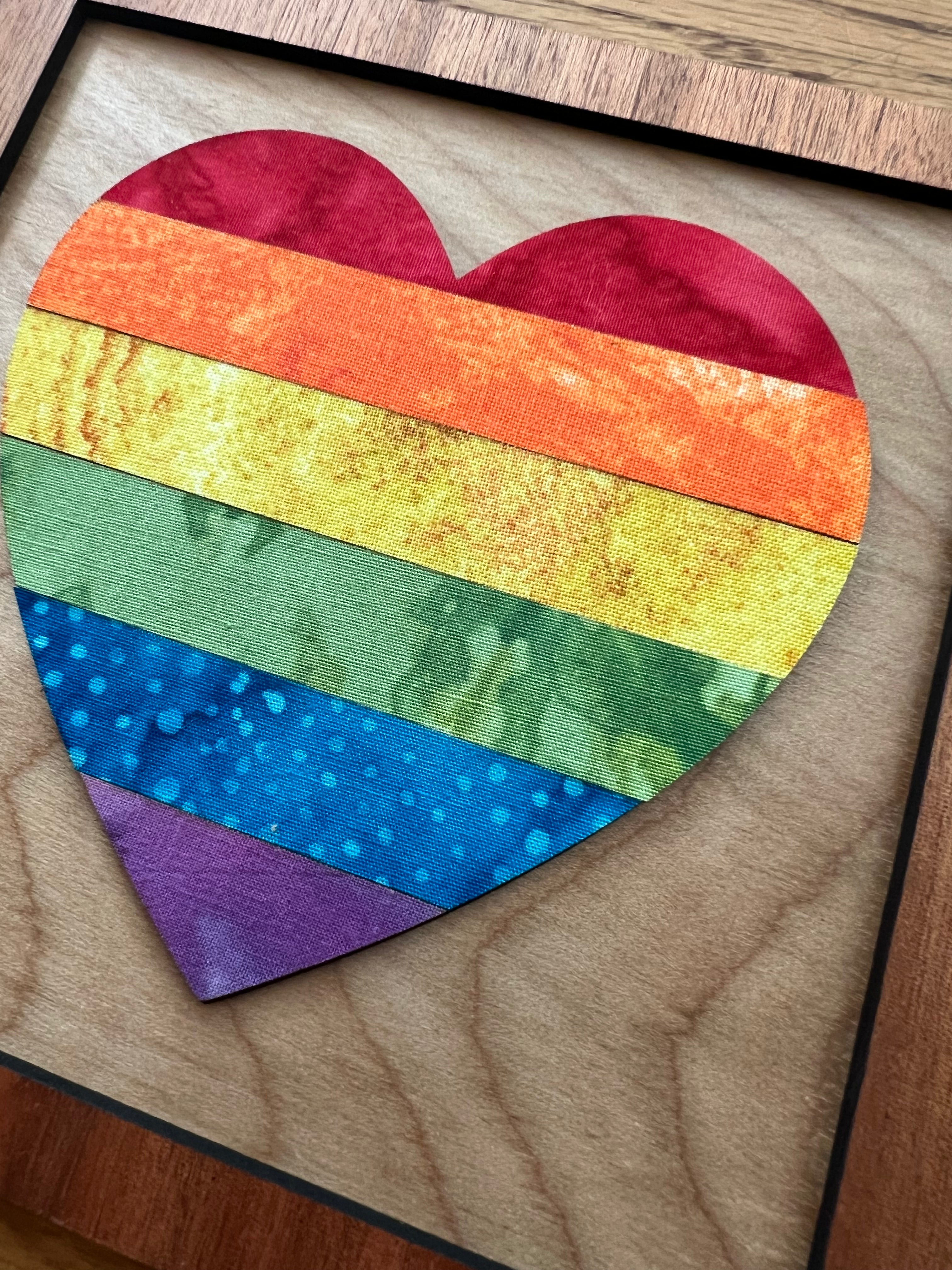 Rainbow heart-shaped patch on a wooden surface
