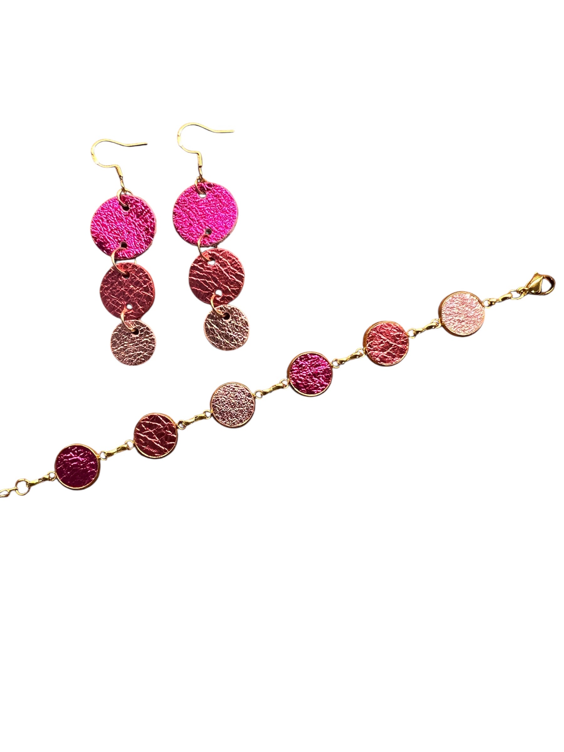 Bracelet & earrings with pink and gold circular pendants on a white background