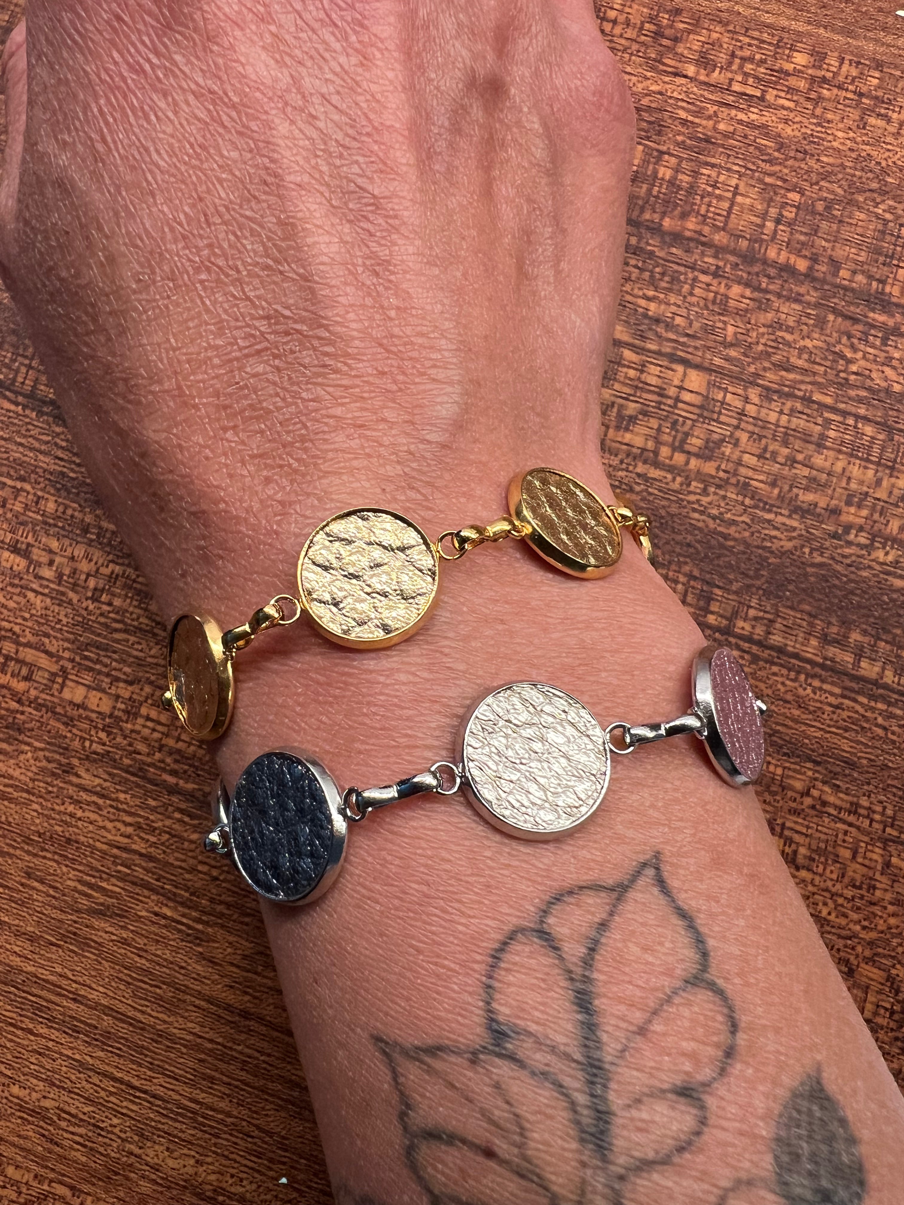 Two Everlink bracelets on a tattooed wrist.