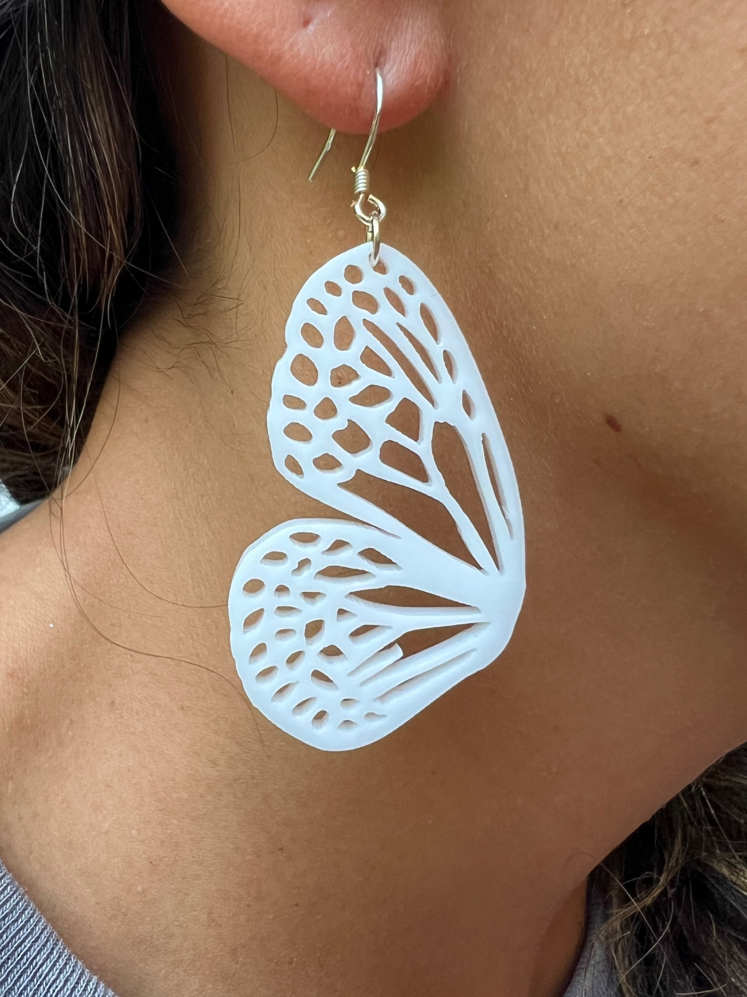 Butterfly-shaped earrings worn by a person